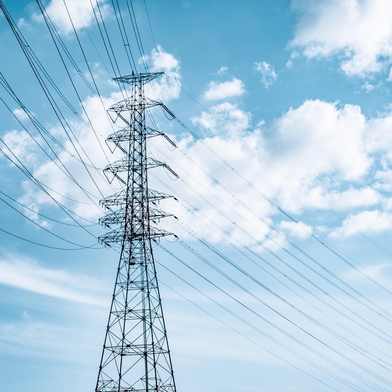 black electric tower under blue sky and white clouds during daytime