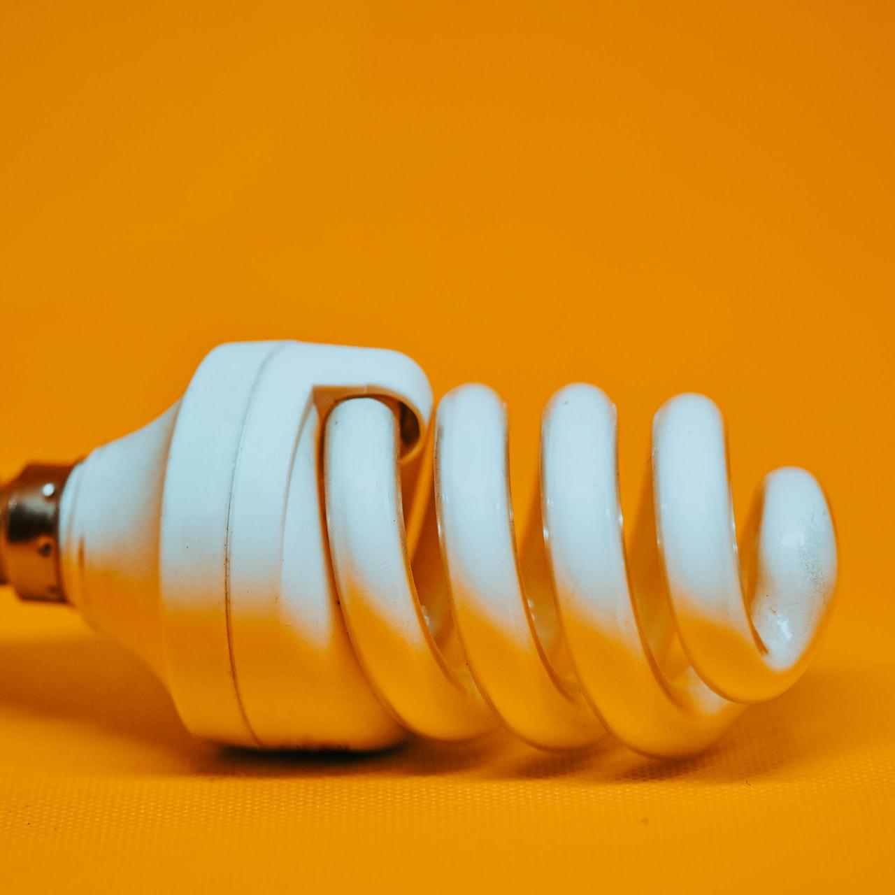 white spiral light bulb on yellow surface